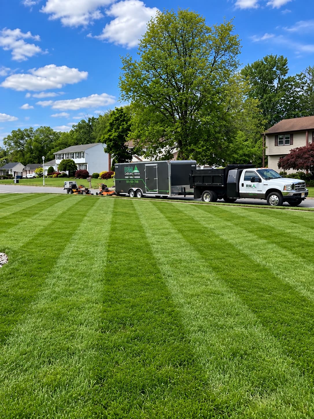 RM Landscape & Design LLC equipment and freshly maintained lawn